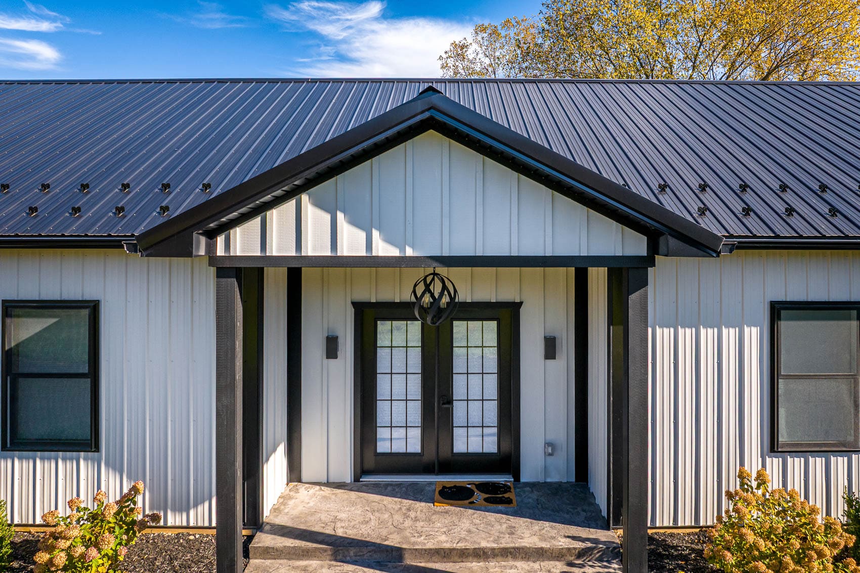 Close entry detail of white barndominium with black roof