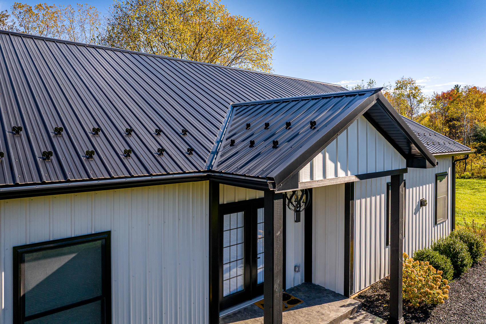 Roof and entry detail of white barndominium home